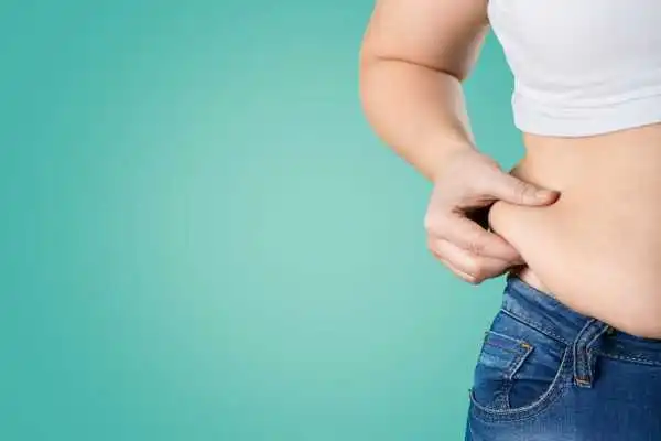 Image of woman pinching her love handles to show weight gain Sunningdale